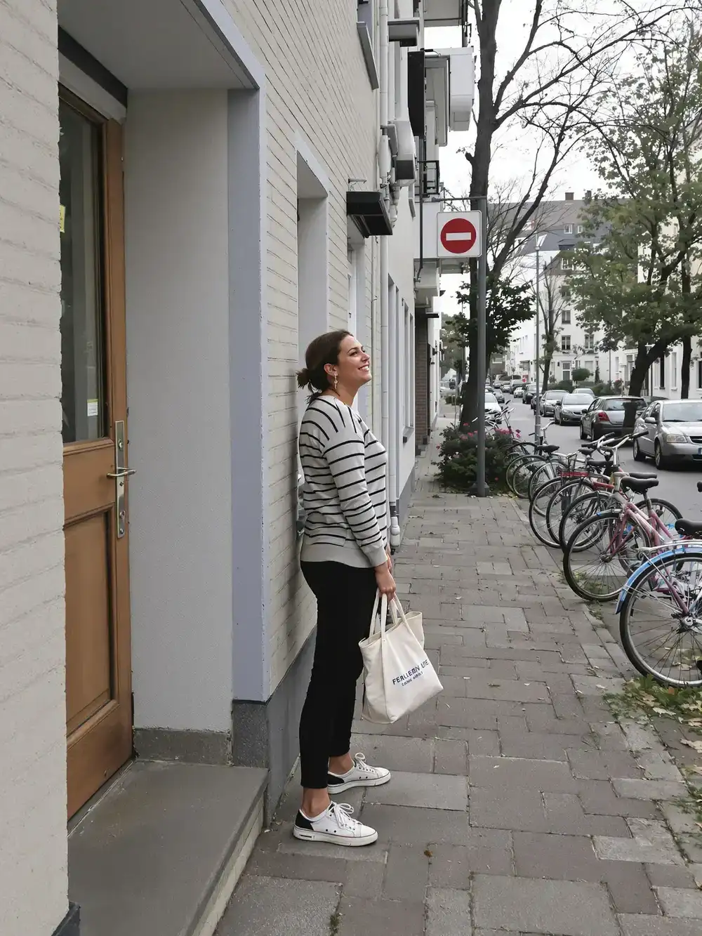 A woman steps out of her front door onto the street in the morning